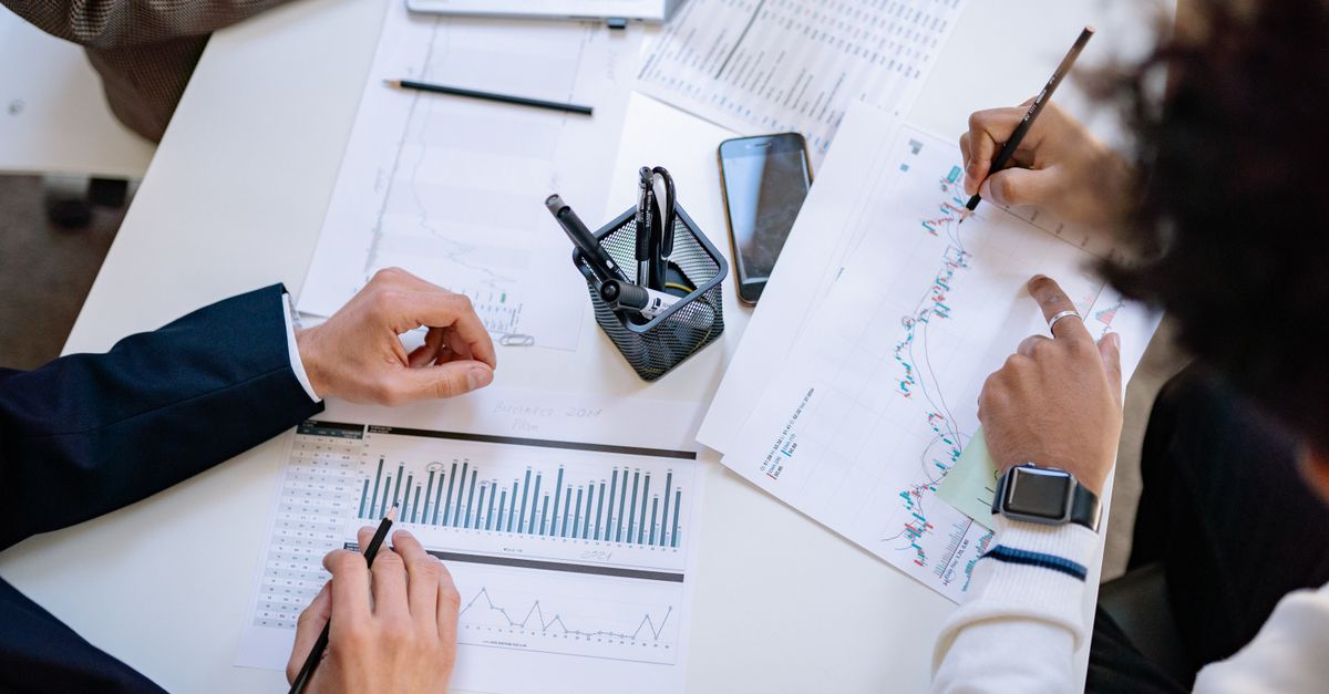 Business team analyzing financial charts and graphs during a collaborative meeting.